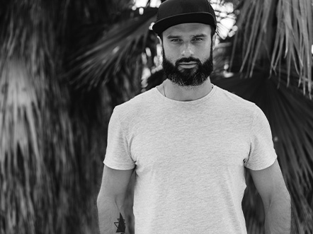 handsome male model with beard wearing gray blank t-shirt and a black snapback cap